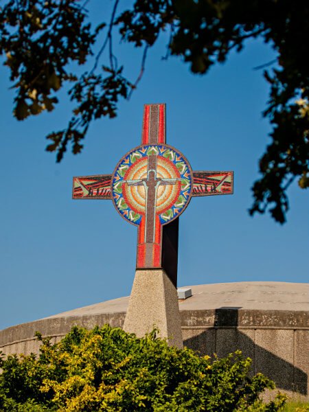 Colorful religious cross with red and blue on the top of a building